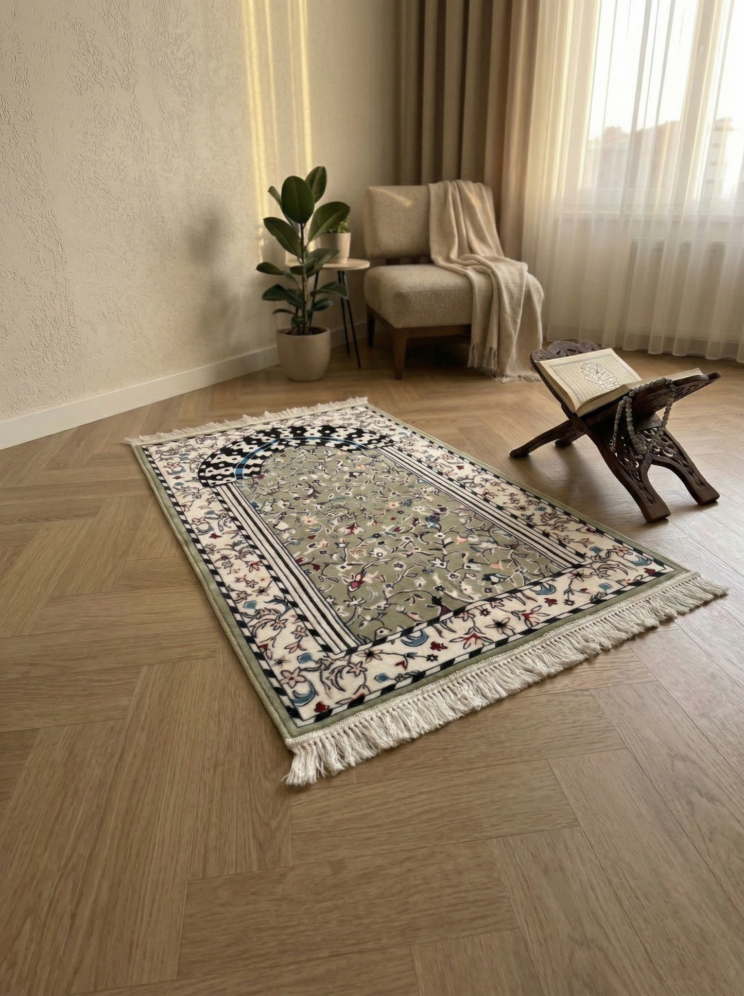 Lifestyle-Aufnahme des Noura Premium Gebetsteppichs Modell Rawdah in Salbeigrün, platziert in einem modern eingerichteten Wohnzimmer mit Holzboden und Tageslicht neben einem hölzernen Koranhalter.